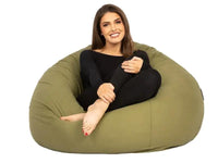 Woman sitting inside a large green bean bag chair on a white background