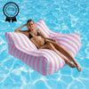 Woman lounging on a pink striped bean bag pool float in clear blue water with a 'Product Review Winner' badge.